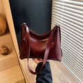 Elegante borsa a secchiello in ecopelle rosso intenso con tracolla larga e vintage - Rosso