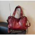 Dettaglio della borsa tote in morbida pelle rosso scuro con cerniere metalliche - Borgogna