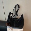 Zwarte lederen hobo-tas met witte contraststiksels en een pluche bolvormige hanger - Zwart met hanger