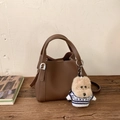 Détail d'un sac seau vintage en cuir marron avec pendentif chien mignon sur bois - Café (Avec Pendentif)
