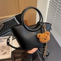 Black PU leather bucket bag with round handle and brown teddy bear charm accessory - Black