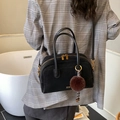 Klassische schwarze Tasche aus Wildlederimitat mit goldenen Details und Plüsch-Anhänger - Schwarz
