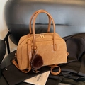 Retro-Handtasche aus braunem Wildleder mit Pelz-Pompon und goldenen Beschlägen im Studio - Braun