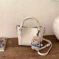 Détail d'un sac seau en cuir crème avec un joli pendentif chien en peluche marron - Blanc (Avec Pendentif)