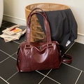 Bolso tote vintage color burdeos con costuras en X y herrajes plateados sobre azulejos - Burdeos