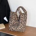 Detalle del bolso tote de felpa con estampado de leopardo, logo dorado y textura suave de piel - Leopardo Marrón Negro (NM-2323) / Leopardo Marrón