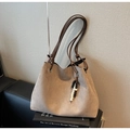 Vue détaillée du grand sac cabas en daim taupe avec perles décoratives sur canapé noir - Khaki