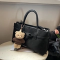 Matte black tote bag with elegant teddy bear charm on a minimalist white stone surface - Black With Pendant