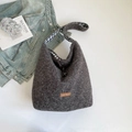 Gray plush tote bag with plaid lining and drawstring closure in a stylish setting - Black