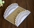 Macro detail of laser-cut wedding invitation with vine floral patterns on a dark wood table - Kraft Paper Inner Style