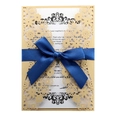 Detail of laser cut gold floral invitation with a navy blue satin bow and white insert - Beige Gold