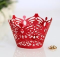 Macro detail of red laser-cut crown cupcake wrapper with intricate floral hollow pattern - Pearlescent Red