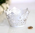 Macro shot of white laser-cut cupcake wrapper with elegant lace crown pattern - White