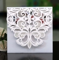 Close-up of white laser-cut wedding invitation with baroque floral hollow patterns - White