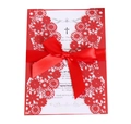 Macro view of red laser-cut floral invitation with silk ribbon bow and white inner sheet - Pearlescent Red