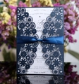 Detailed laser-cut navy wedding invitation with silk bow on a reflective surface - Ink Blue