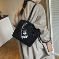 Black leather bucket tote bag with gold logo, striped scarf, and dog charm accessory - Black with Pendant