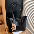 Grande borsa tote nera lucida con ciondolo a forma di orso e sottili spalline in luce naturale - Nero con ciondolo