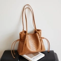 Dettaglio della texture struzzo sulla borsa tote marrone con coulisse laterali - Marrone