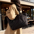 Grote zwarte gewatteerde shopper gedragen door model in een beige trenchcoat - Zwart