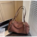 Brown frosted suede Boston shoulder bag with adjustable straps on a leather bench - Coffee