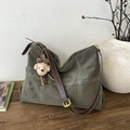 Détail du sac cabas en daim gris-vert avec surpiqûres blanches et pendentif chien peluche - Avec Pendentif / Vert