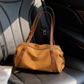 Sac à bandoulière en daim marron mat avec lanières réglables sur un siège en cuir - Marron