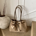 Close-up of khaki suede tote bag with leather strap detail and plush bear charm - Khaki with Pendant