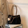 Close-up of black suede tote bag with brown leather handles and a cute plush bear charm - Black with Pendant