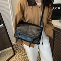 Retro black PU leather messenger bag worn over the shoulder with vintage texture - Black