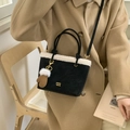 Détail du sac cabas en daim noir avec bordure en peau lainée et pendentif de gant - Noir
