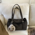 Detalle del bolso tote de cuero marrón oscuro con colgante de conejo en sofá blanco - Con Colgante / ébano