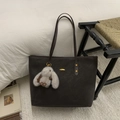 Dettaglio della grande borsa tote in pelle scamosciata marrone con fibbia e ciondolo a coniglio - Caffè con Ciondolo