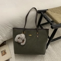 Dettaglio della borsa tote in pelle scamosciata verde scuro con hardware dorato e ciondolo - Verde con Pendente