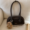 Detalle de bolso bandolera de ante marrón con costuras blancas y colgante de peluche suave - Café Con Colgante