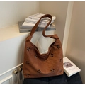 Dettaglio di una borsa Hobo in camoscio marrone con fiori tagliati al laser e tracolla annodata - Marrone