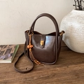 Detailed view of deep brown vintage leather bag with gold buckle and wooden bead tassel - PU Coffee (JC-1293)