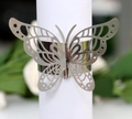 Macro view of silver butterfly napkin ring with laser-cut hollow pattern and polished finish - Reflective Silver