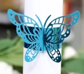 Macro detail of laser-cut blue butterfly napkin ring with a glossy metallic finish - Reflective Blue