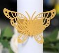 Gros plan sur un rond de serviette papillon doré découpé au laser pour mariage - Doré