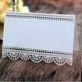 Elegant white laser-cut heart place card with intricate lace edge on vintage wood table - White