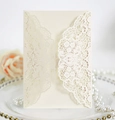 Detail of laser-cut lace wedding invitation with elegant cream floral patterns - Ivory