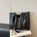 Minimalist black leather tote bag with gold metal rings and retro embossed tag - Black