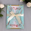 Dettaglio invito nozze blu intagliato a laser con carta rosa floreale e fiocco bianco - Blu Tiffany