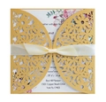Detail of laser-cut gold wedding invitation with floral patterns and a cream silk ribbon - Gold