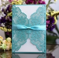 Laser cut wedding invitation in lake blue with floral hollow pattern and silk ribbon bow - Tiffany Blue
