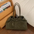 Détail d'un grand cabas en daim vert foncé avec pochette sur fond de bois naturel - Vert Olive