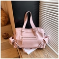 Dettaglio della borsa tote in pelle rosa con fibbie laterali su base di legno - Rosa