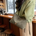 Sac fourre-tout rétro en daim vert foncé avec boucle dorée en C dans un café d'hiver - Vert
