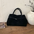 Detail van zwarte matte suède draagtas met leren riem op een houten ondergrond - Zwart